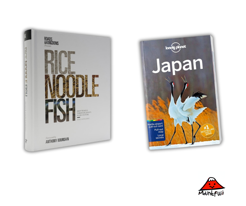 Zwei Japan-Reiseführer nebeneinander: Links "Rice Noodle Fish: Deep Travels Through Japan's Food Culture" mit minimalistischem grau-weißem Cover und Vorwort von Anthony Bourdain, rechts der "Lonely Planet Japan" Reiseführer mit dem charakteristischen Cover zweier tanzender Kraniche vor goldenem Herbstlaub. Unten rechts ist das Mount Fuji Logo mit dem lächelnden roten Berg-Maskottchen zu sehen