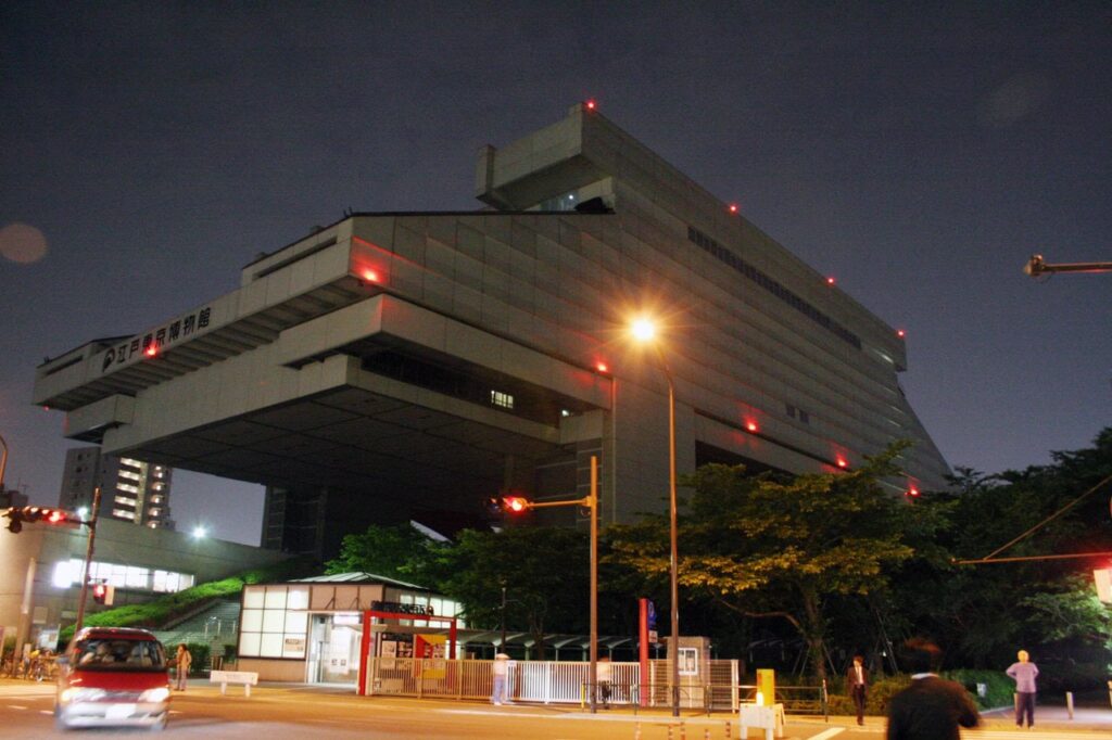 Das futuristische Edo-Tokyo Museum bei Nacht mit seiner charakteristischen Architektur im Metabolismus-Stil, inspiriert von traditionellen Kurazukuri-Bauten