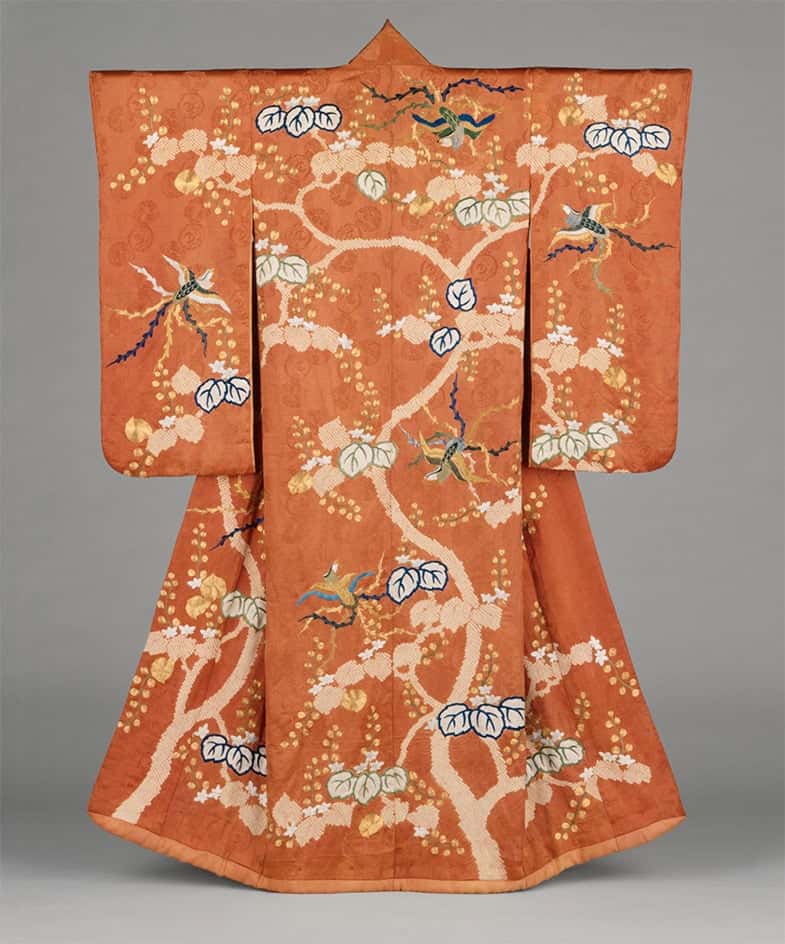 Ein wunderschöner traditioneller Kimono in warmen Orangetönen mit einem eleganten Muster aus Kirschblüten, Vögeln und floralen Motiven. Die weiten Ärmel und die kunstvolle Gestaltung zeigen die klassische Kimono-Form.