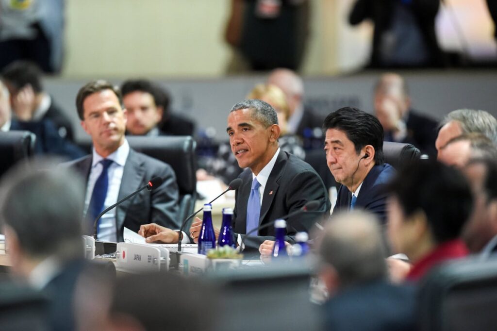 Politische Vertreter bei einer internationalen Konferenz, darunter erkennbar Barack Obama in der Mitte, während einer Diskussionsrunde an einem Konferenztisch.