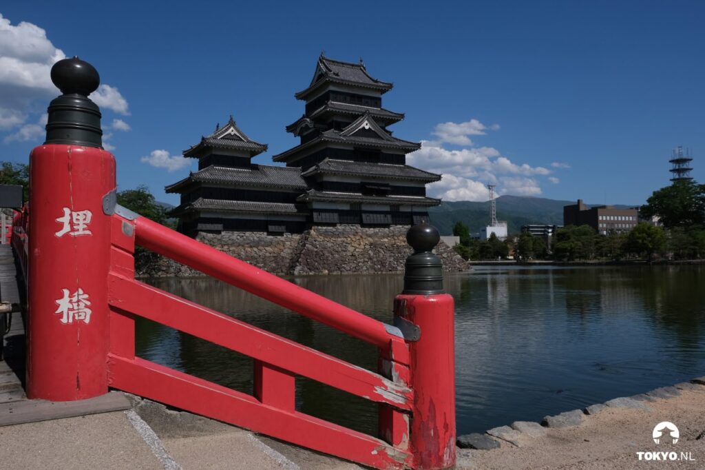 Rote Brücke über den Wassergraben mit Blick auf das Matsumoto-Schloss in Nagano