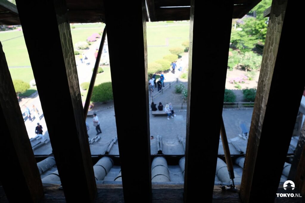 Blick durch die Schießscharten des Matsumoto-Schlosses auf den Garten und Besucher