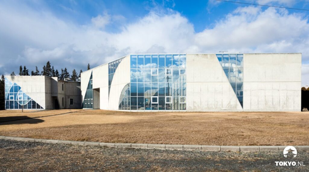 Modernes geometrisches Gebäude mit Glasfassade und Betonwänden in Matsumoto bei Tageslicht