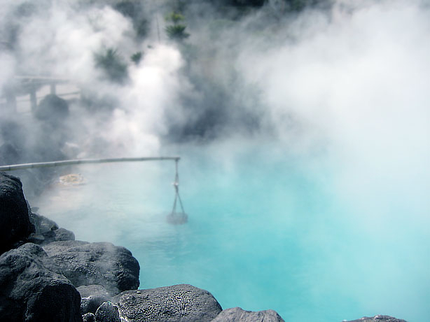 Türkisblaues geothermales Onsen mit intensivem Dampf, vulkanischen Mineralien und natürlichen Felsformationen in japanischer Thermallandschaft