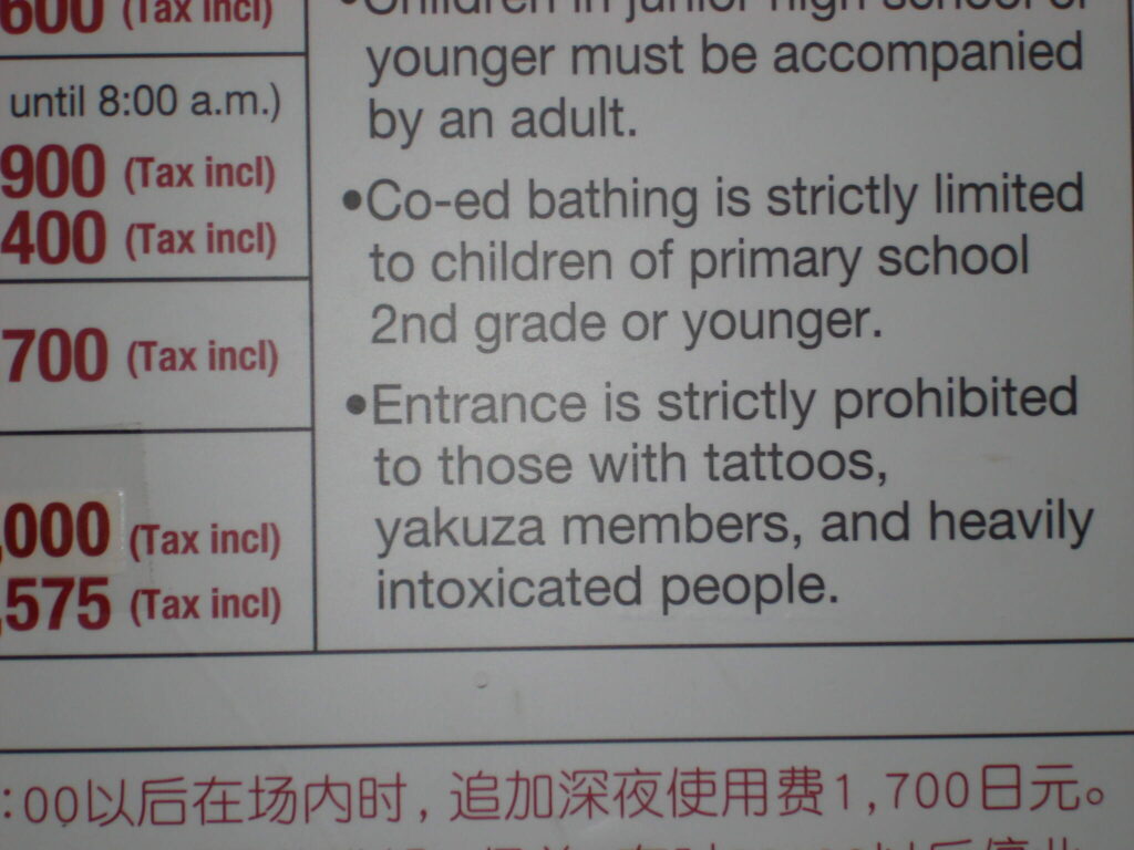 Englischsprachige Onsen-Hausordnung mit Preisliste und Verhaltensregeln für ausländische Besucher in japanischen heißen Quellen