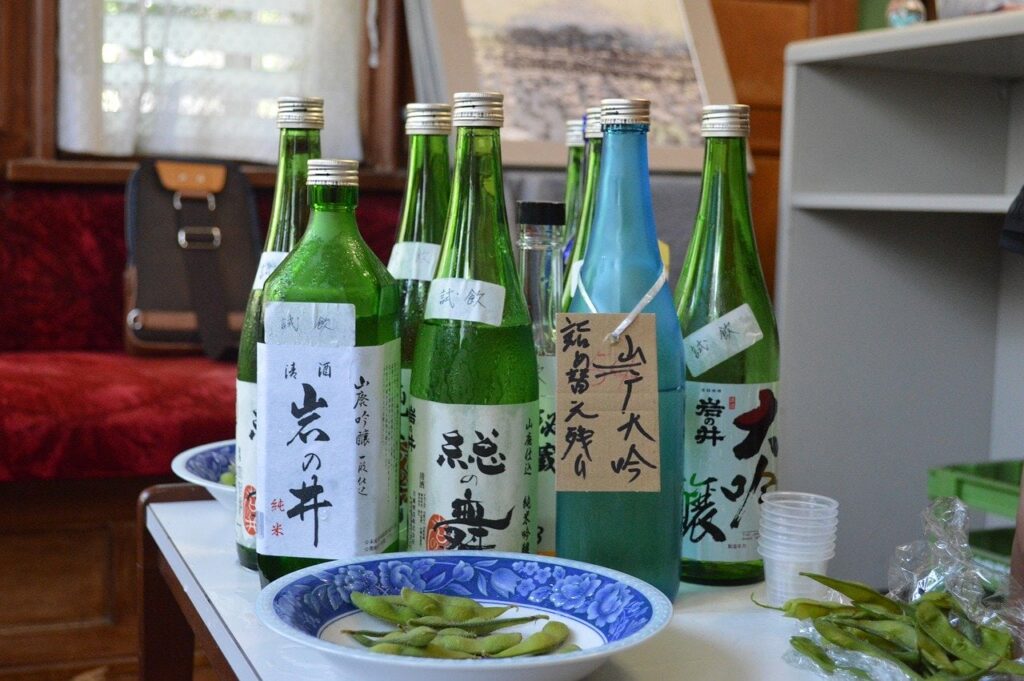 Sake-Verkostung in Kobe mit beschrifteten Gefäßen im Vordergrund