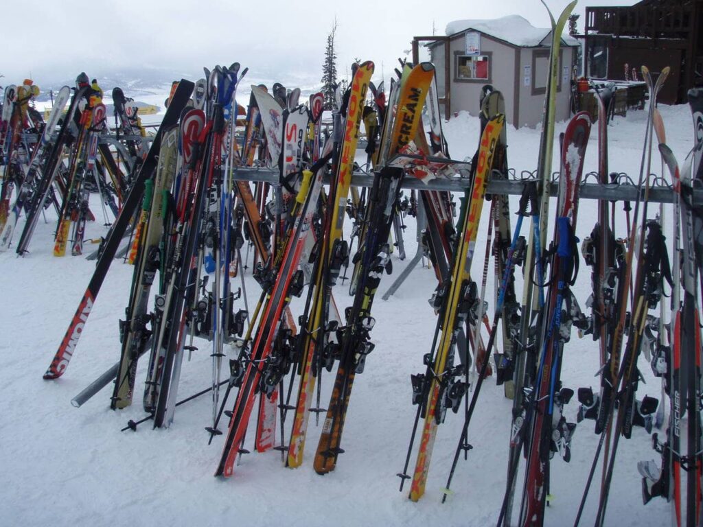 Viele Ski stehen in einer Reihe im Schnee