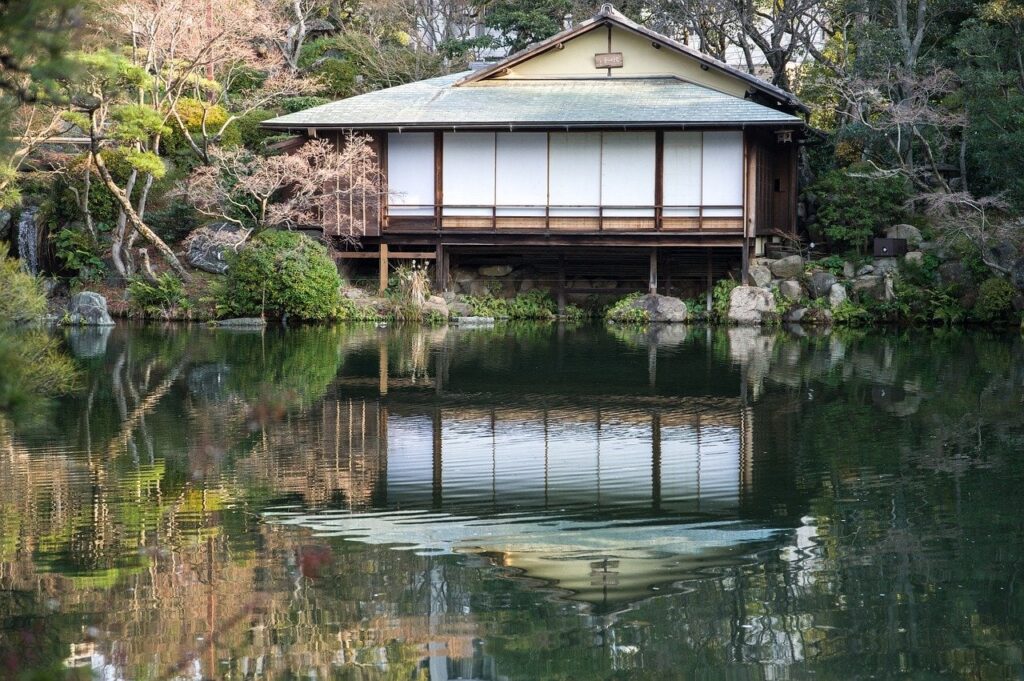 Japanischer Garten Sorakuen mit einem Haus und einem Gewässer im Vordergrund