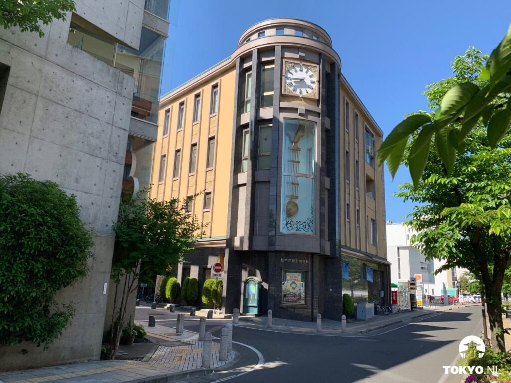 Gebäude des Matsumoto-Uhrenmuseums an einer Straßenecke mit großer Uhr und Pendel