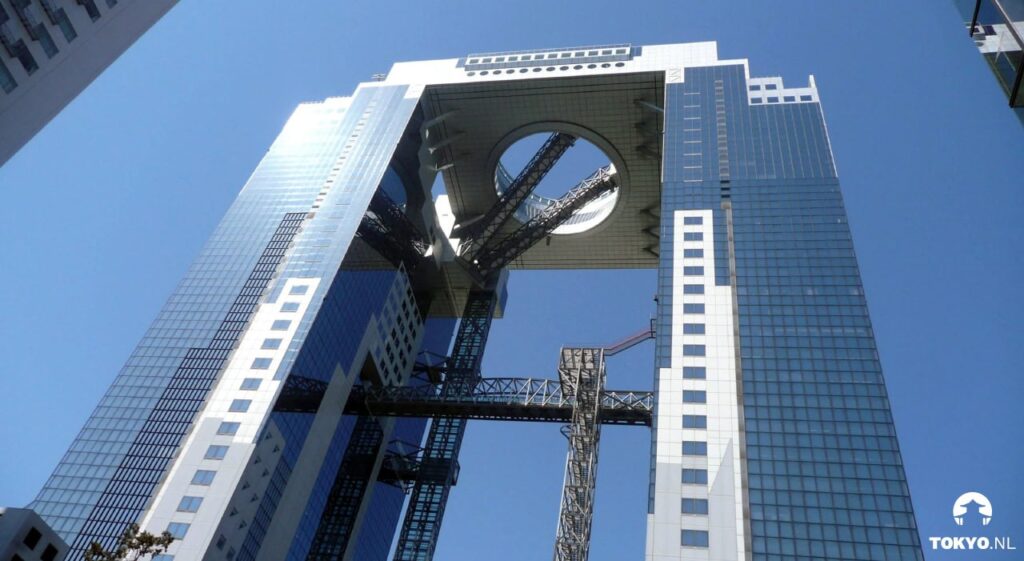 Umeda Sky Building in Osaka von unten fotografiert mit charakteristischer Brückenverbindung zwischen den Zwillingstürmen
