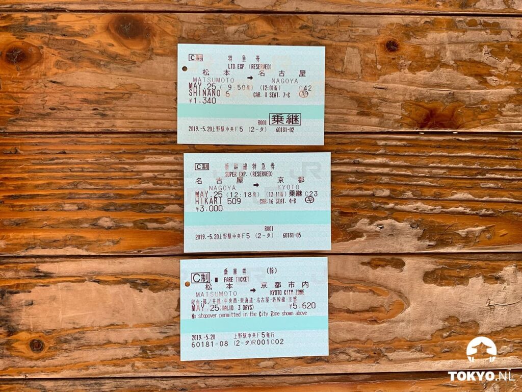 Drei japanische Zugtickets auf Holztisch für die Strecke Matsumoto über Nagoya nach Kyoto