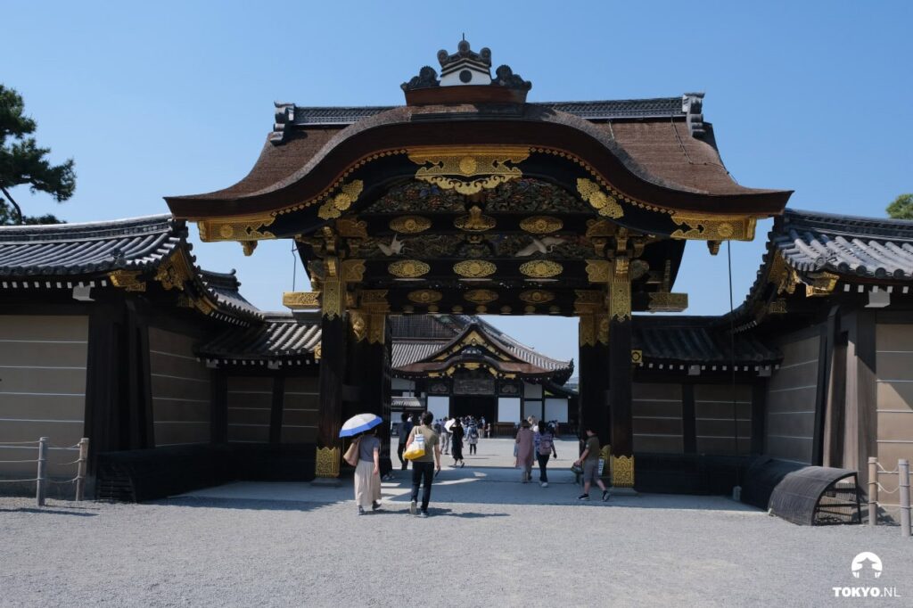 Prächtiges Eingangstor des Nijo-Schlosses in Kyoto mit goldenen Verzierungen, traditioneller japanischer Palastarchitektur und Besuchern