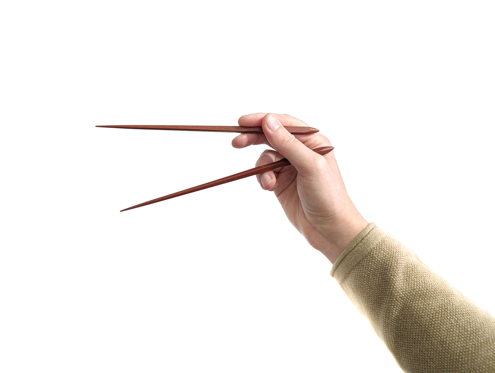 Mit einer Hand Essstäbchen festhalten