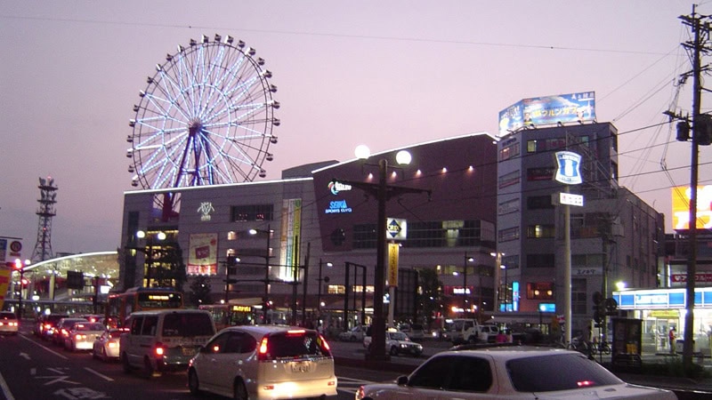 Kagoshima Stadtpanorama bei Sonnenuntergang mit Amuran-Riesenrad und Einkaufszentrum