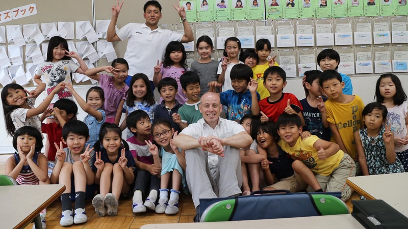 Marco umringt von japanischen Schuelern in japanischer Schule.