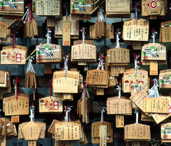 Traditionelle japanische Ema-Wunschtafeln aus Holz hängen an einem Shinto-Schrein
