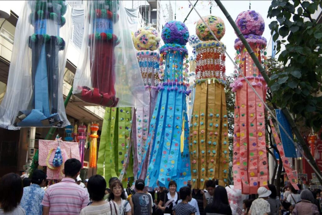 Große bunte Tanabata-Dekorationen aus Papier und Bambus hängen über einer Straße in Sendai während des Sternenfestivals