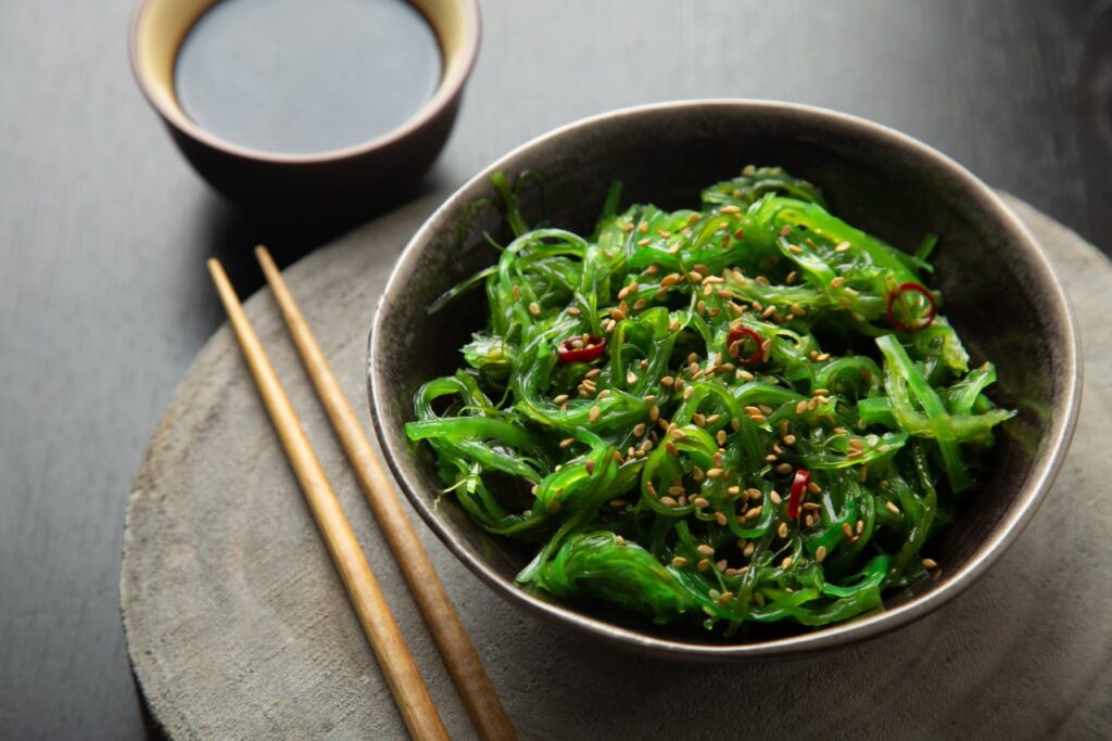 Schale und Stäbchen mit Wakame (Seetang-Salat)